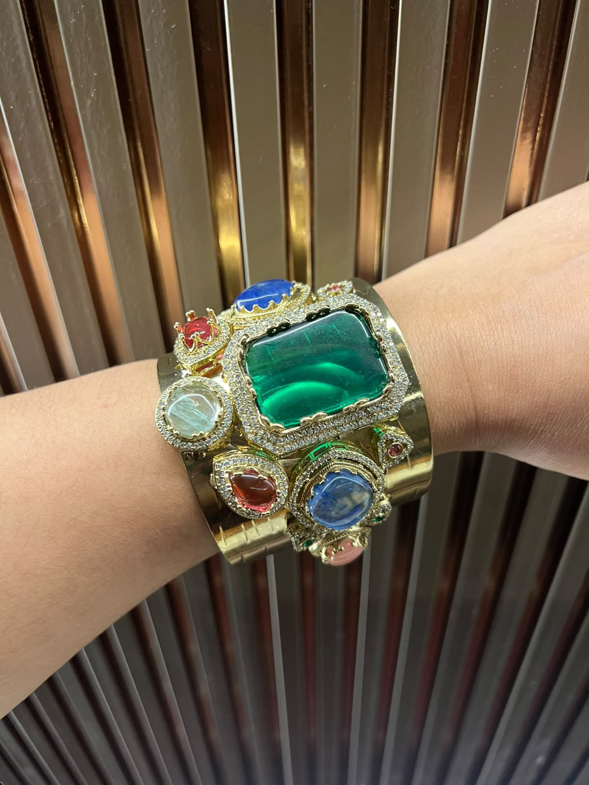 Sabyasachi handcuff bracelet with emerald-green centre stone and multicolour accents